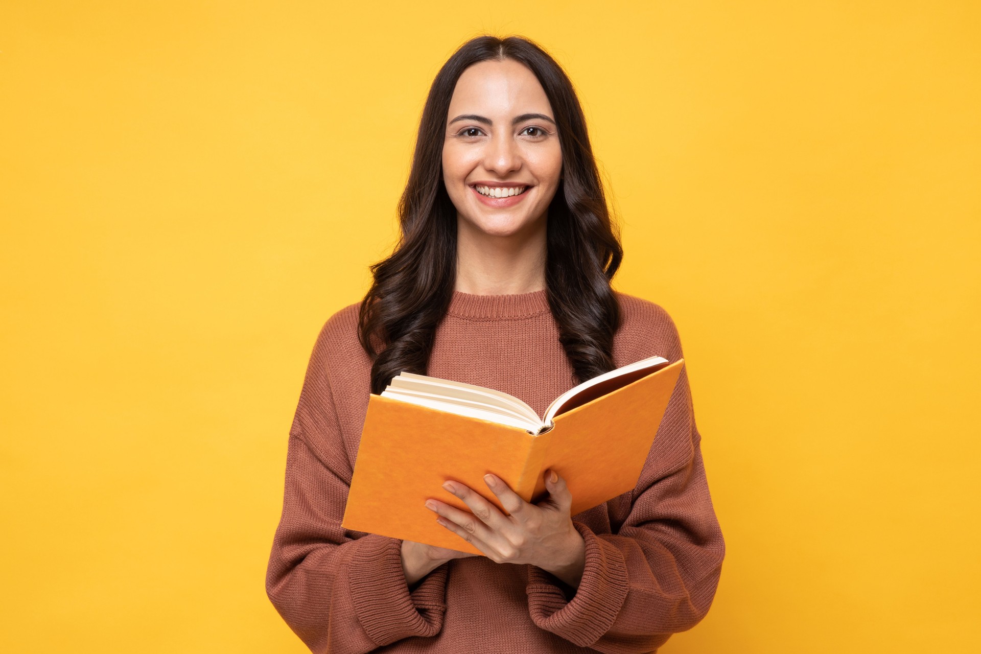 Portrait of female college student on yellow background stock photo